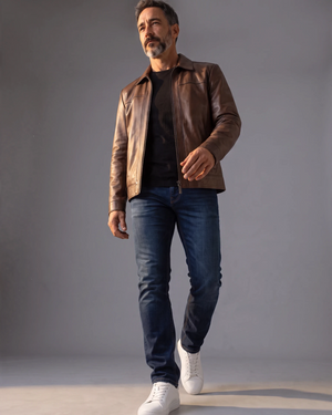 Man wearing a Hilda Leather shadow brown lambskin jacket with a clean design and regular fit over a black t-shirt.