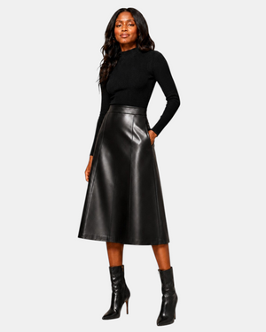 Model wearing Hilda Leather black lambskin A-line midi skirt with a black turtleneck and heeled ankle boots